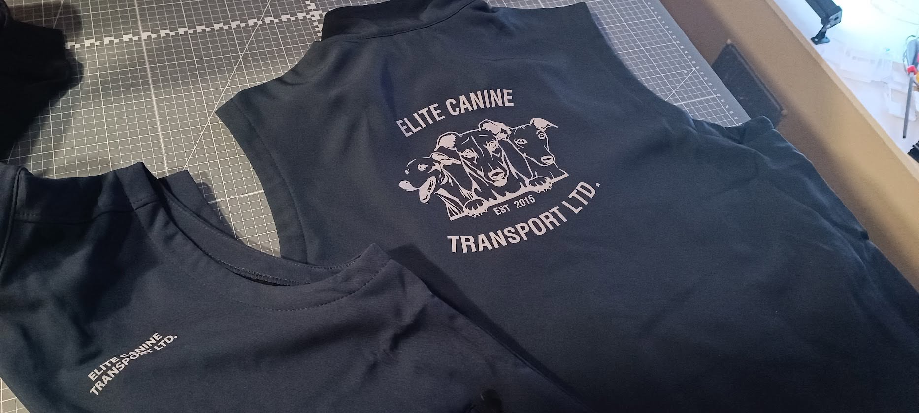 Black branded bodywarmers printed for Elite Canine Transport by Time for Designs