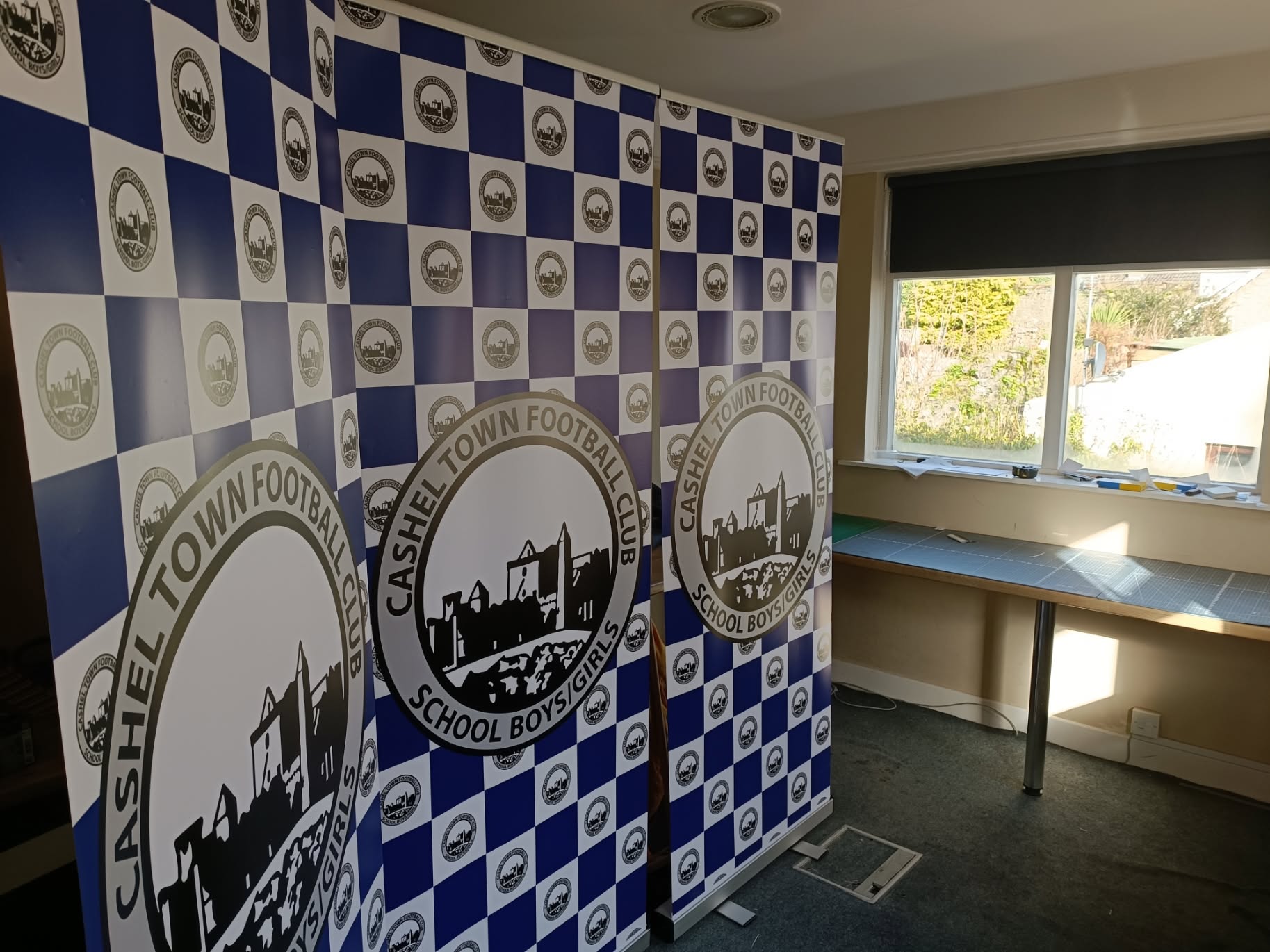 Three coordinated Cashel Town Football Club roll-up banners produced by Time for Designs