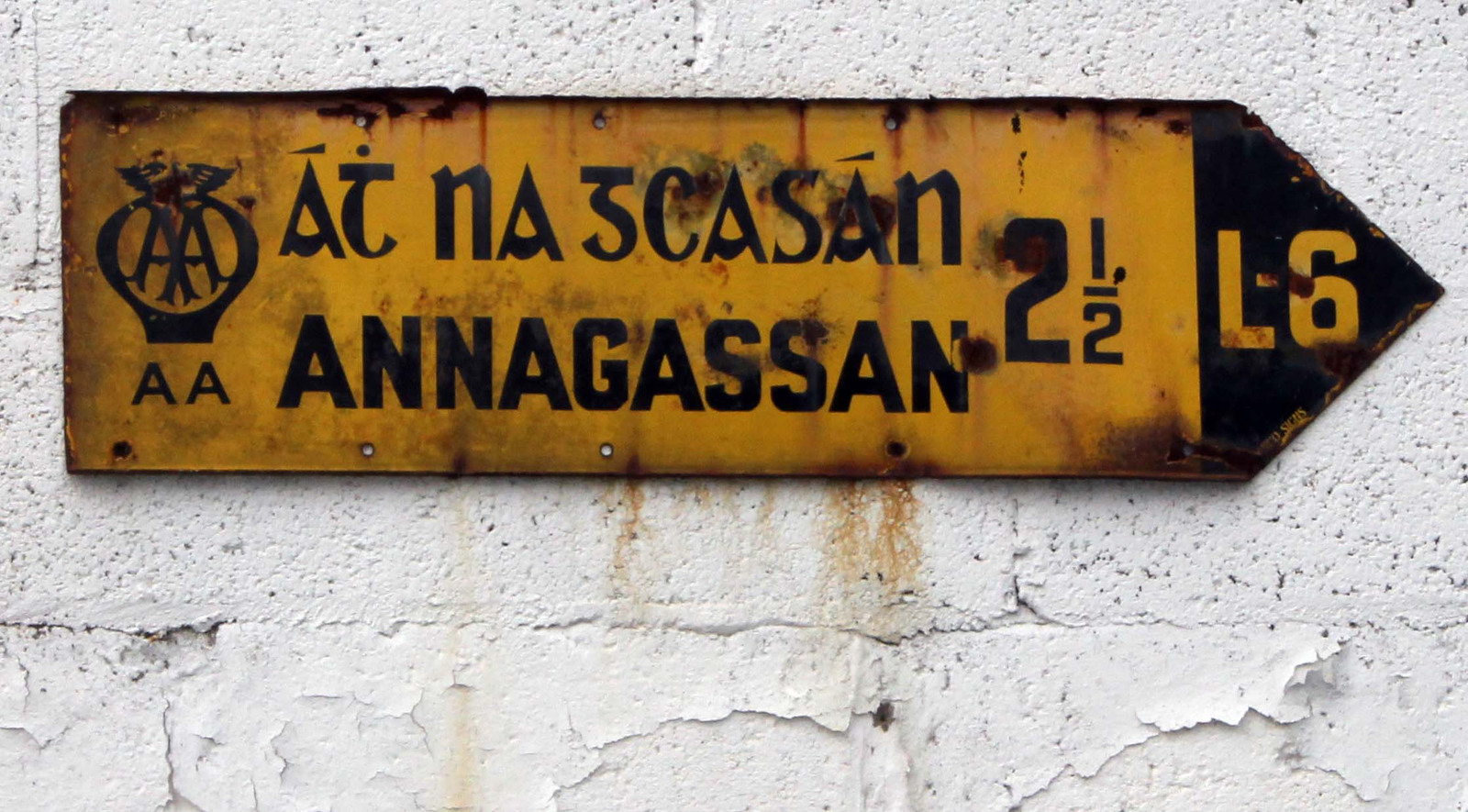 An old yellow AA fingerpost showing the Irish and English names for Annagassan with a shared right-pointing arrow.