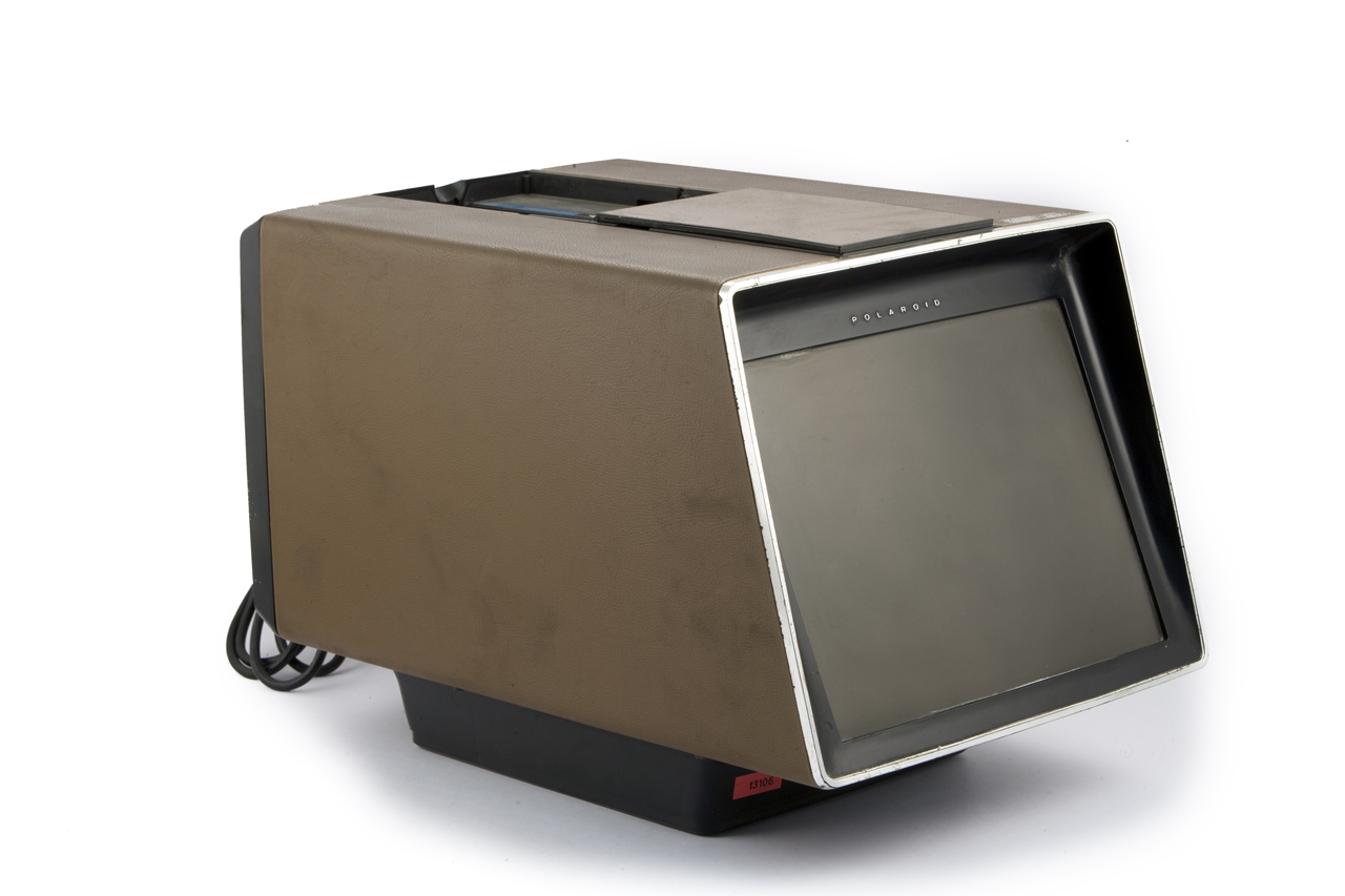 Brown Polaroid Polavision tabletop player with a cassette opening above its built-in screen.
